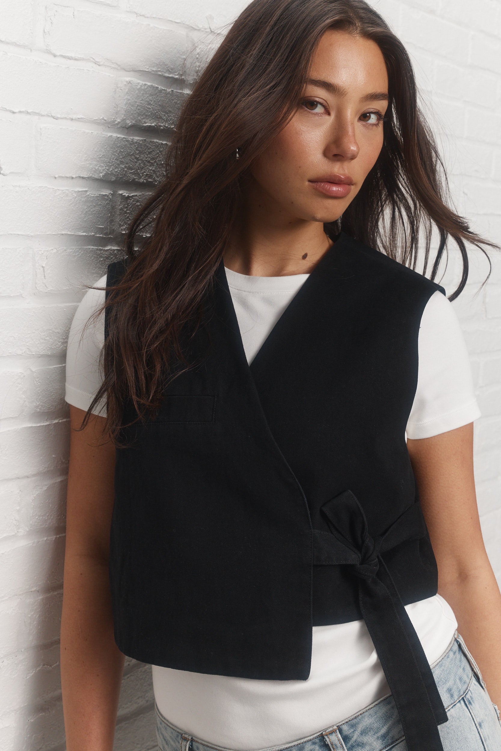 Gigi | La veste noire asymétrique sans manches