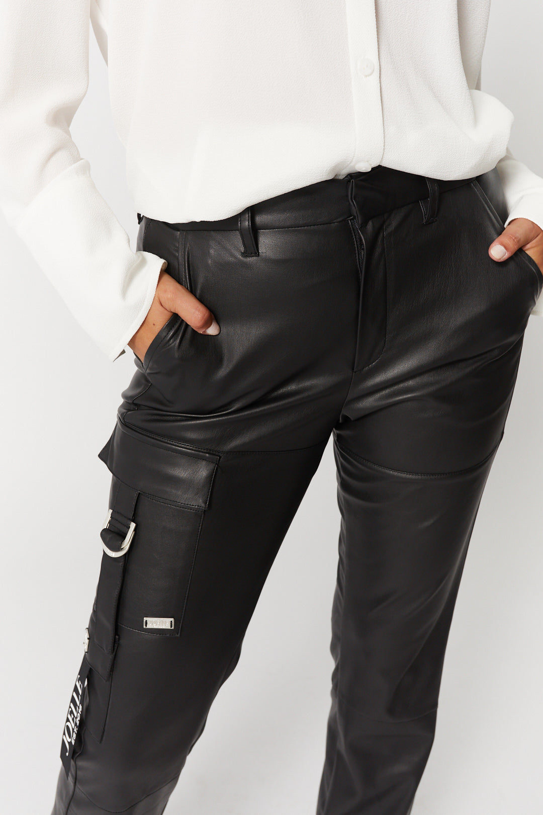 Black leather-effect pants with asymmetrical pockets | Daphne