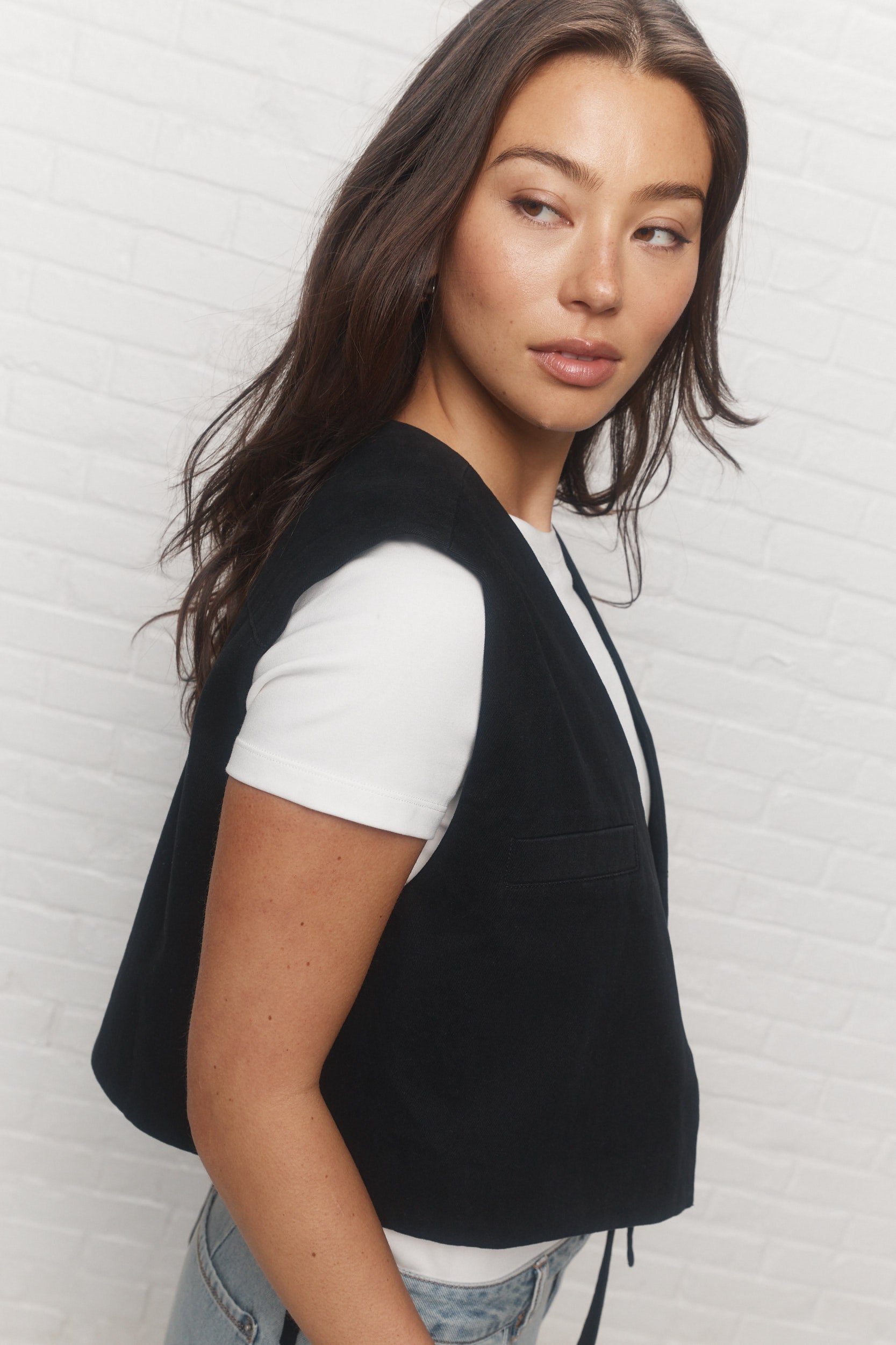 Gigi | La veste noire asymétrique sans manches