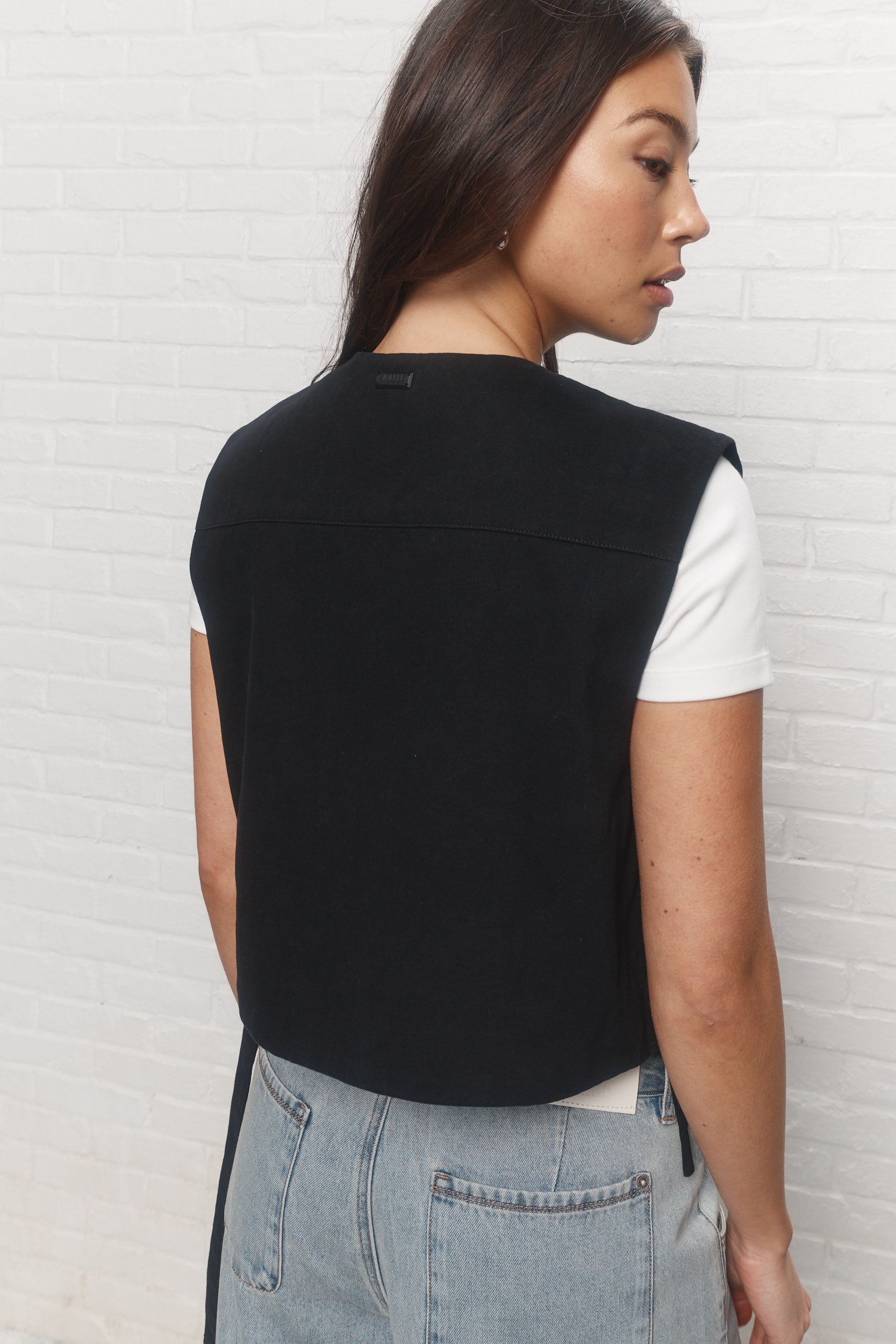 Gigi | La veste noire asymétrique sans manches
